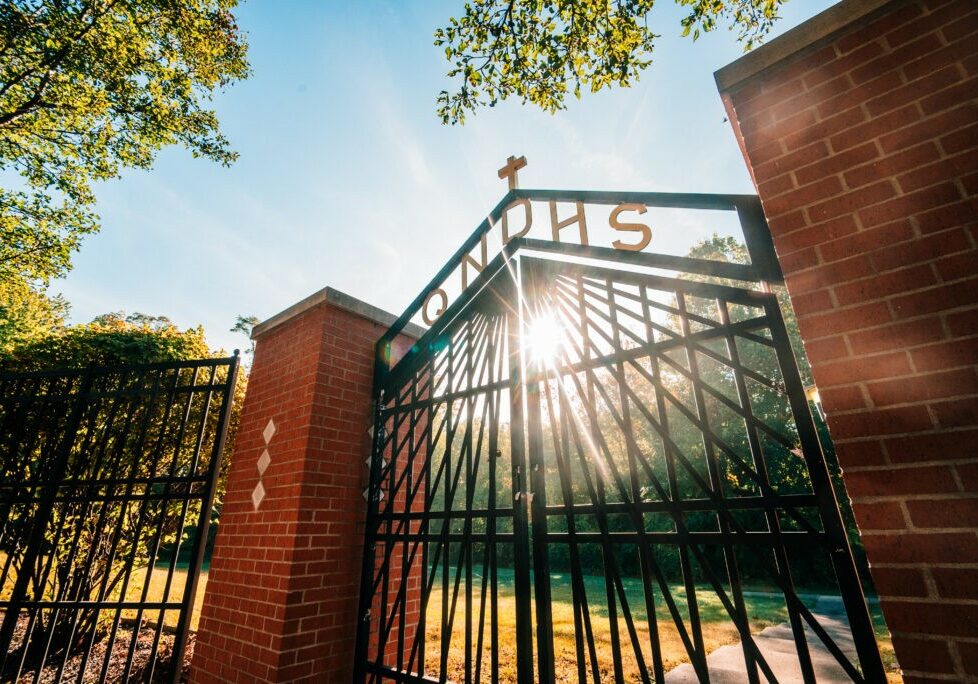 QND Mission - QND entrance gate with sunlight shining through, symbolizing faith and tradition at Quincy Notre Dame High School