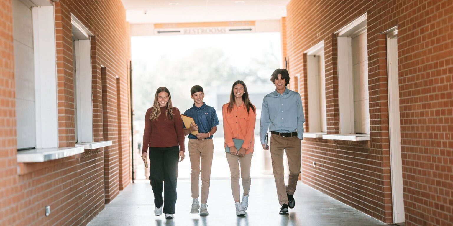 QND students walking through a hallway on campus, representing community and open enrollment at Quincy Notre Dame High School